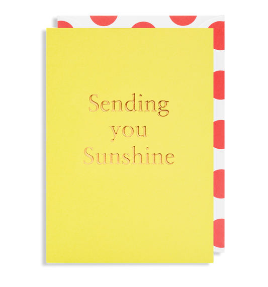 A vibrant yellow SENDING YOU SUNSHINE - GREETING CARD by Oxted, beautifully gold-embossed, graces the scene, accompanied by an envelope with a striking red polka dot interior.