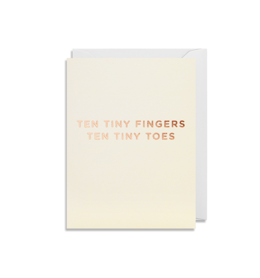 A minimalist greeting card from Oxted, titled "TEN TINY FINGERS TEN TINY TOES - GREETING CARD," features metallic rose gold text on a cream background.
