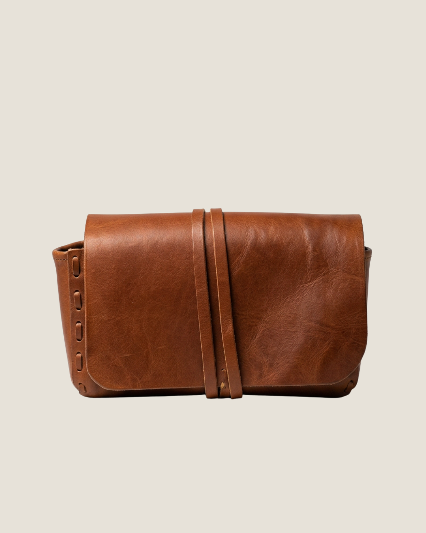Brown leather bag on a beige background