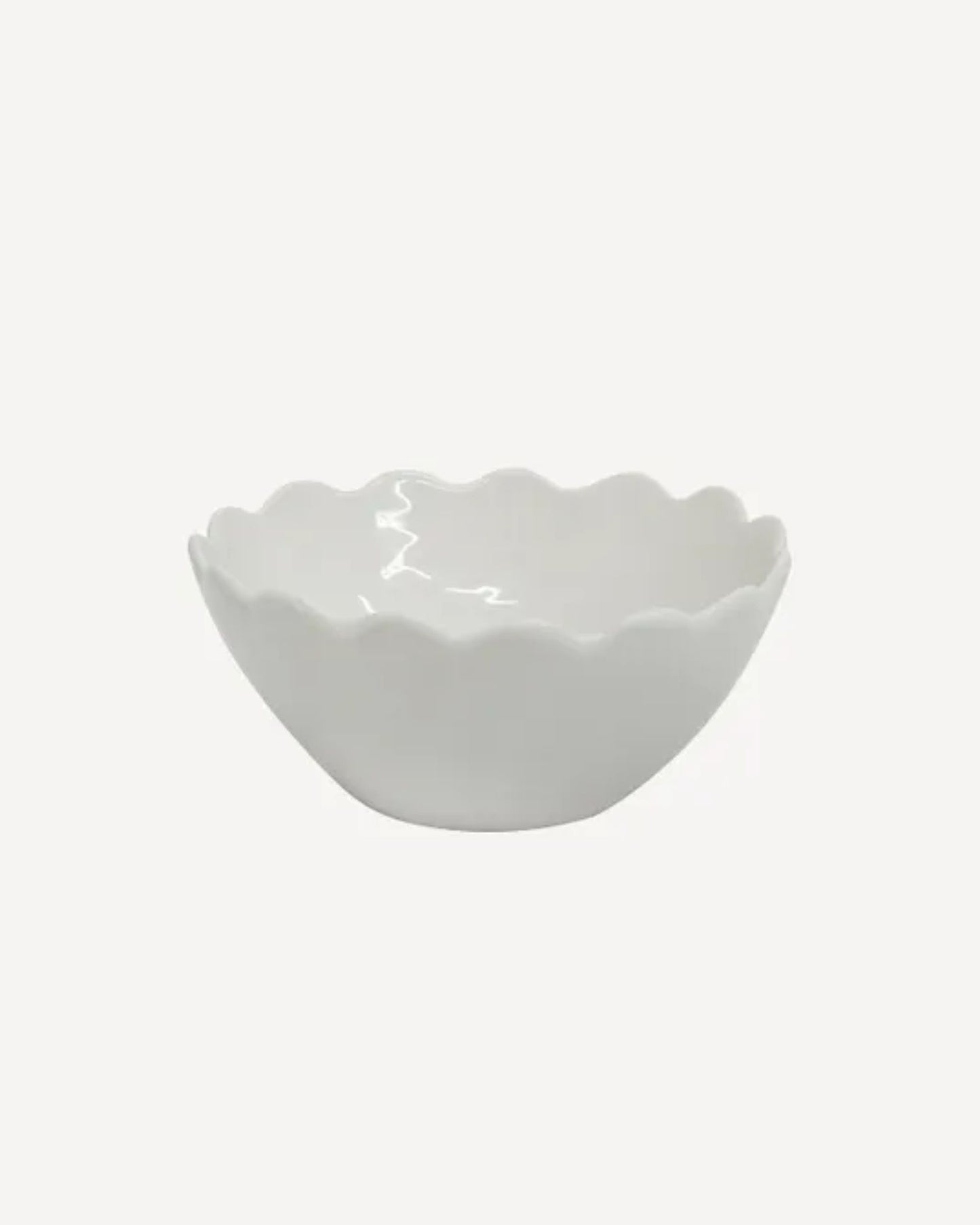 The PETAL CEREAL BOWL by French Country, showcasing an elegant petal design, gracefully sits on a plain light background, with its scalloped edge adding a touch of sophistication.