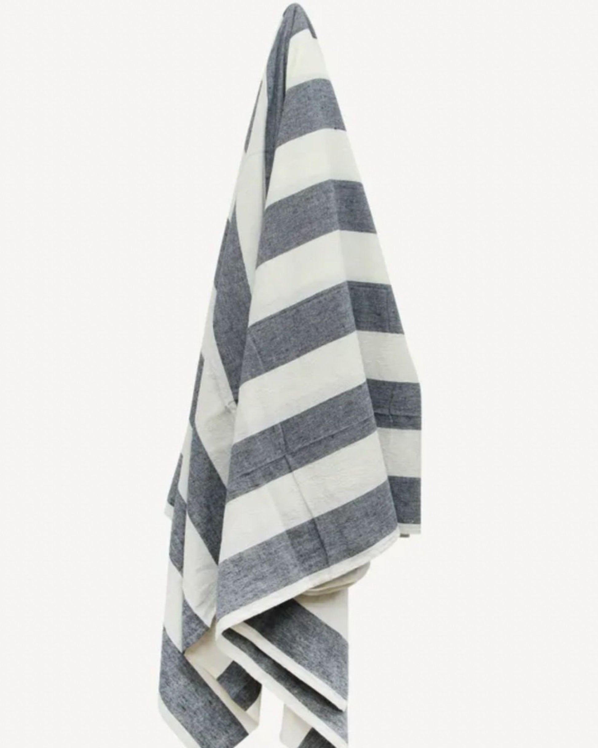 A French Country product, the STRIPED TABLECLOTH BLUE, with its wide horizontal navy blue and white stripes, reminiscent of a sophisticated table setting, elegantly adorns a wall.