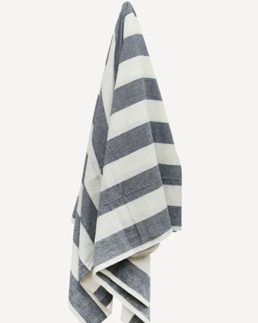 A French Country product, the STRIPED TABLECLOTH BLUE, with its wide horizontal navy blue and white stripes, reminiscent of a sophisticated table setting, elegantly adorns a wall.