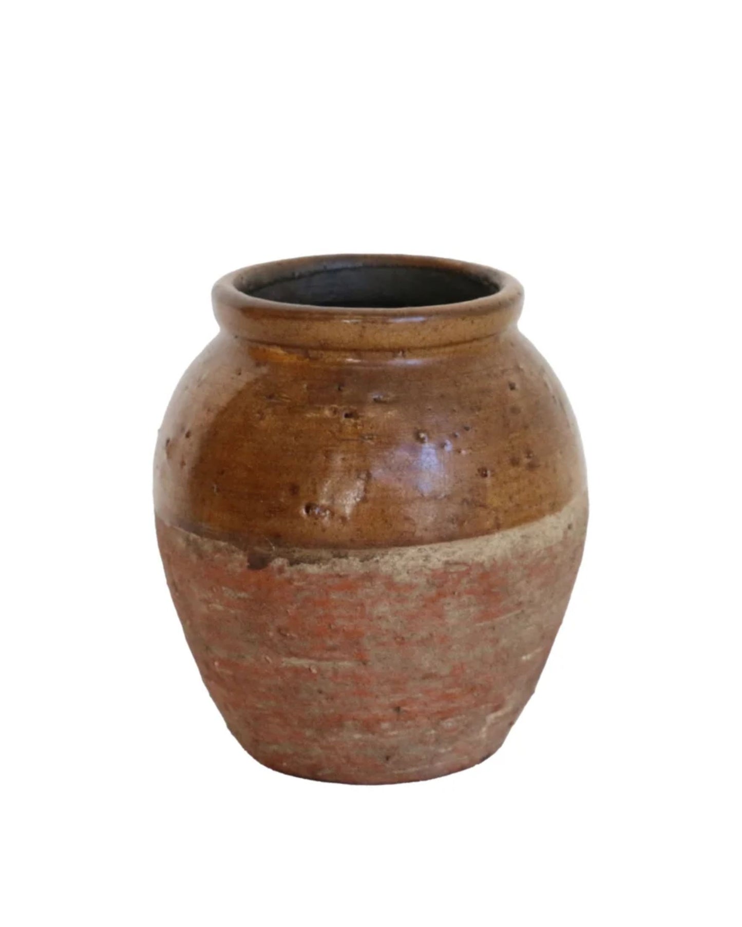 The TUSCAN ROMO URN by CC interiors is a rustic ceramic pot that exudes Mediterranean charm. It features a slightly weathered texture with a wide mouth and rounded body, showcasing two shades of brown—the upper half being darker than the lower. The urn is set against a plain white background.