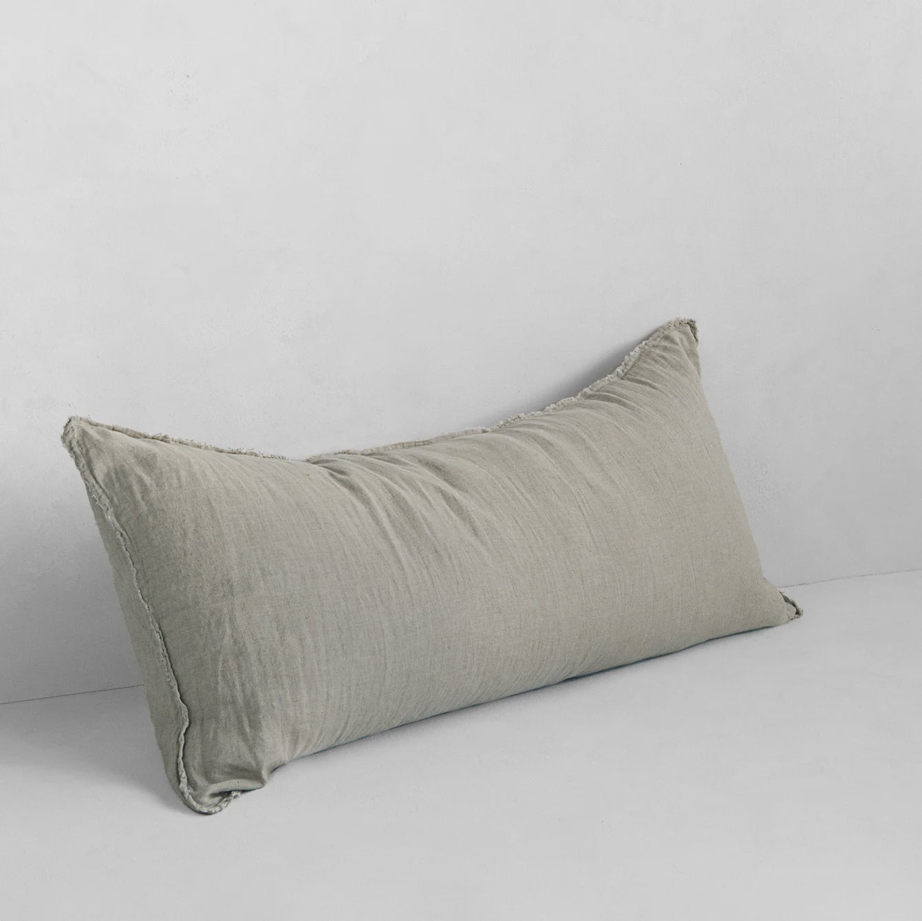 The Hale Flocca Body Pillow Case by Hale Mercantile Co, featuring a rectangular shape and light gray hue with a slightly wrinkled texture, is set against a plain white background.