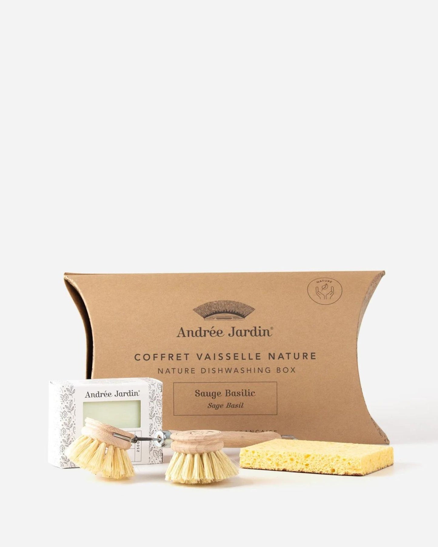 The DISHWASHING GIFT SET by Andree Jardin is a nature-themed collection of sustainable cleaning essentials, featuring a cardboard box labeled Sauge Basilic, two round brush heads, a rectangular sponge, and a small box. These reusable items are elegantly displayed on a white background.