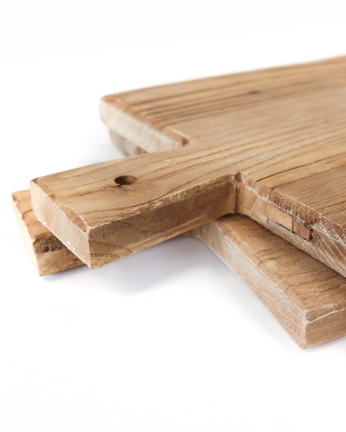 A close-up shot features three Hawthorne ARTISAN SERVING BOARDS, each measuring 45cm x 25cm, neatly stacked with their handles aligned. The natural wood grain texture is prominently displayed, and the top board highlights a small hole in its handle, exemplifying the craftsmanship of these exquisite wood products.