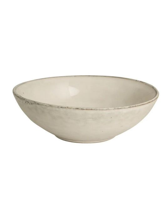 The Broste NORDIC SAND PASTA BOWL exudes coastal elegance with its minimalist, shallow design, slightly uneven edge, and matte Nordic Sand finish, beautifully showcased against a plain white backdrop.