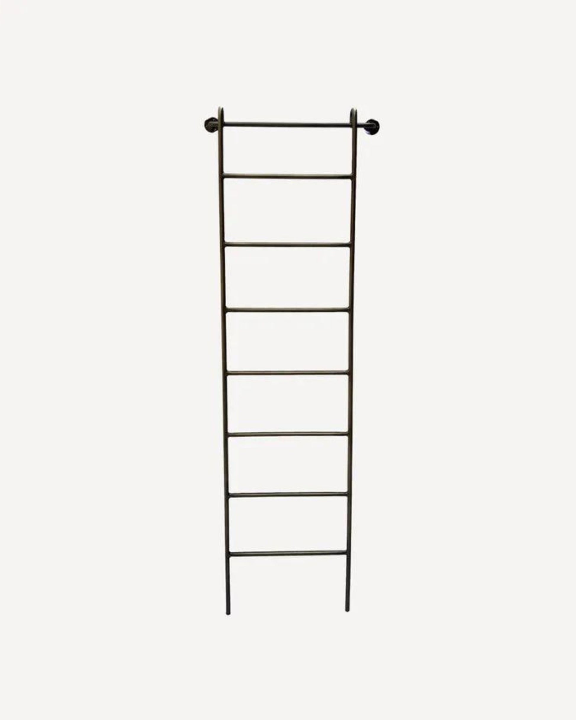The METAL WALL LADDER by French Country is a tall, bronze wall ladder featuring seven evenly spaced rungs against a plain white background. Designed for indoor use, it is supported at the top by two pegs and fits perfectly in a hallway or bedroom.
