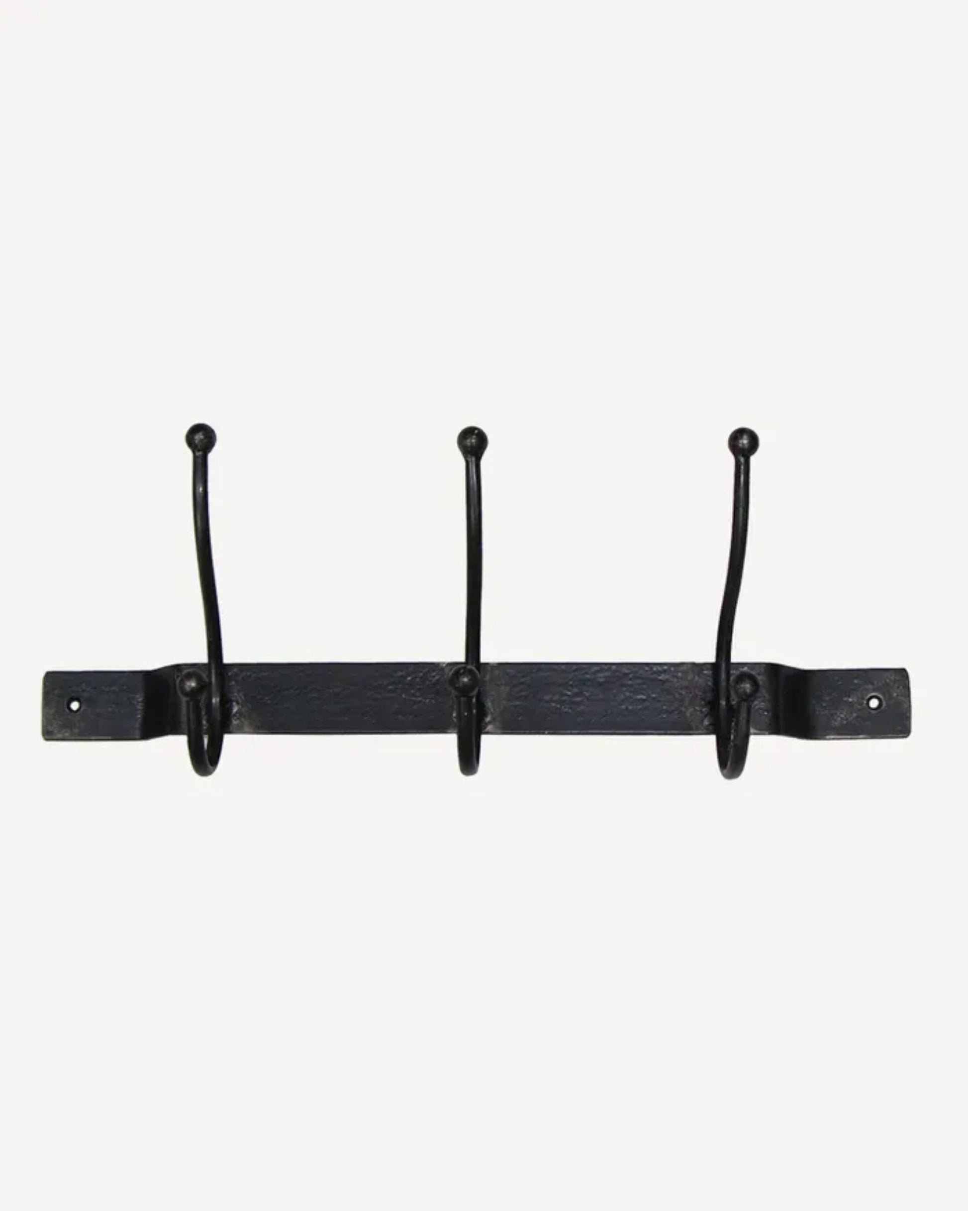 The OLD METAL 3 HOOK BAR by French Country is a black iron wall-mounted coat rack featuring three evenly spaced hooks along a horizontal bar. Each hook has rounded tips, and the bar includes two screw holes at each end for secure mounting. The simple white background emphasizes the rack's sleek design.