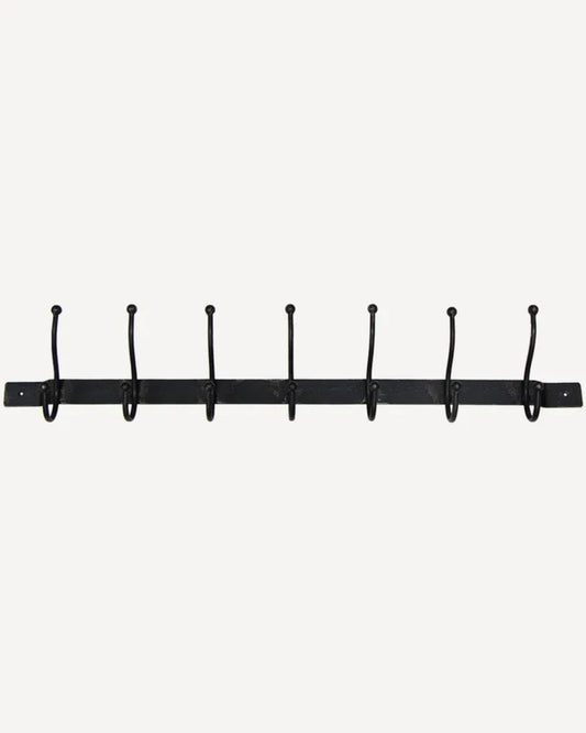 The French Country OLD METAL 7 HOOK BAR, designed for indoor use, is a sleek black metal coat rack featuring seven evenly spaced wall hooks mounted on a horizontal bar against a plain white background.