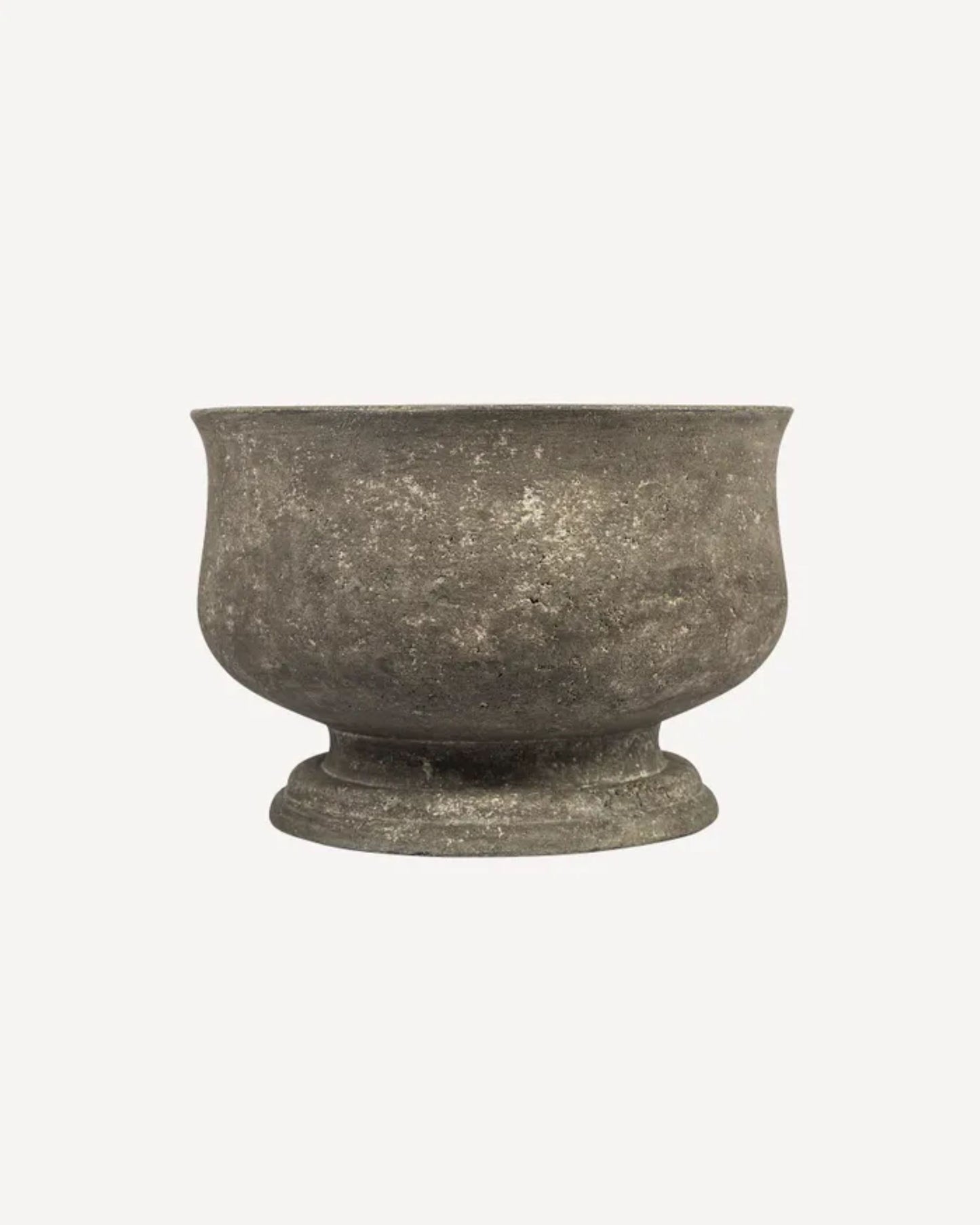 A small ORCHID POT by French Country in a worn, concrete grey finish and textured surface rests against a plain, light background. This planter features a wide, open top and rounded base, making it ideal for an elegant display of orchids.