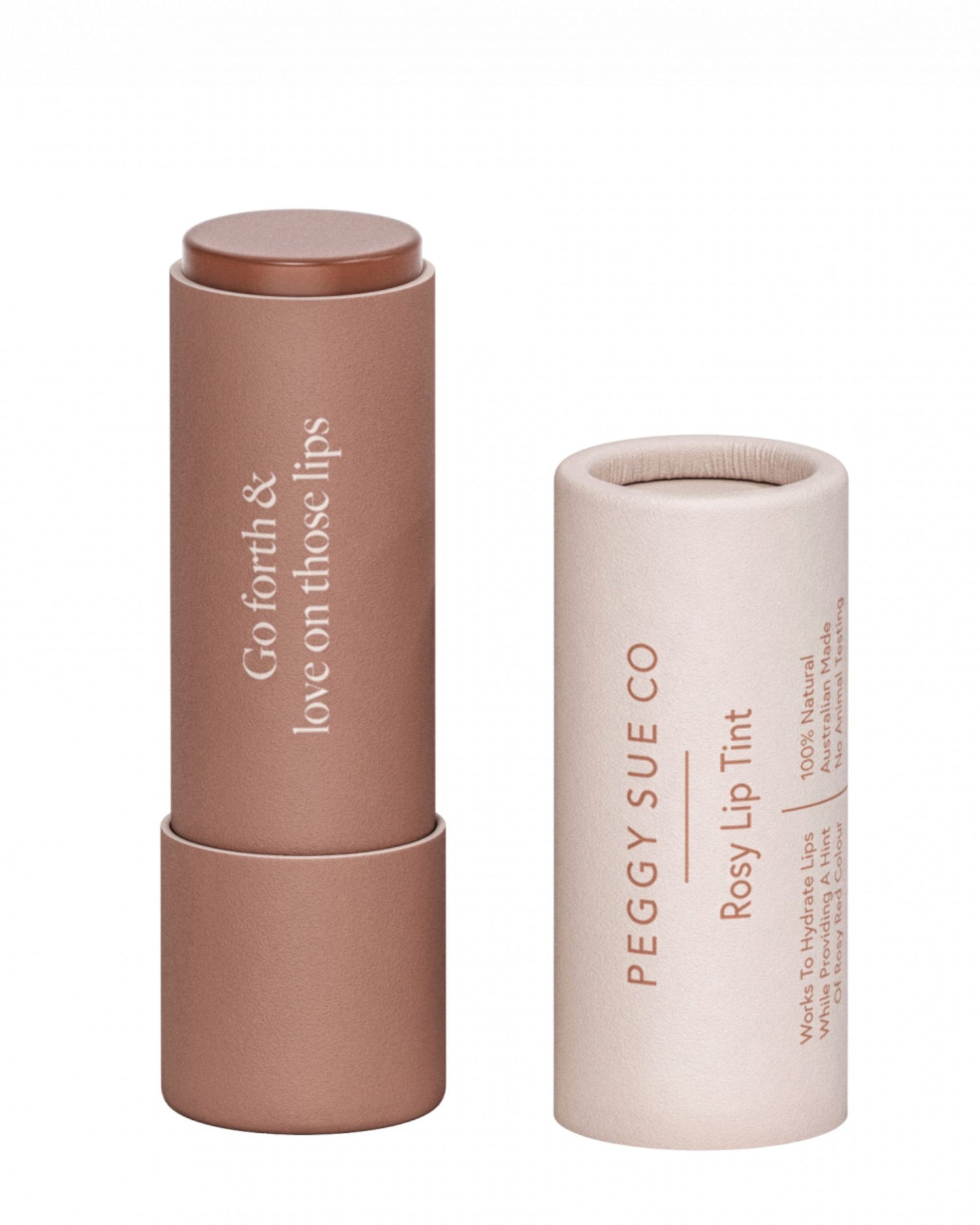 A rosy lip tint called PEGGY SUE - ROSEY LIP TINT by Peggy Sue is displayed in a pinkish-brown, cylindrical tube alongside its matching cap. The tube is infused with natural ingredients and features the phrase "Go forth & love on those lips," while the cap is labeled with "Peggy Sue Co Rosy Lip Tint," making it ideal for maintaining a healthy hydration barrier.