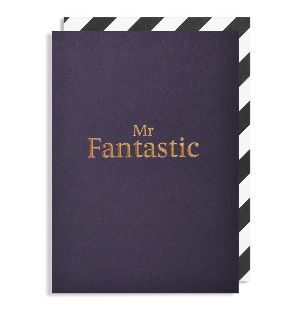 An Oxted MR. FANTASTIC - GREETING CARD, featuring Mr. Fantastic embossed in gold on a dark blue cover, is displayed against a backdrop with partially visible black and white diagonal stripes.