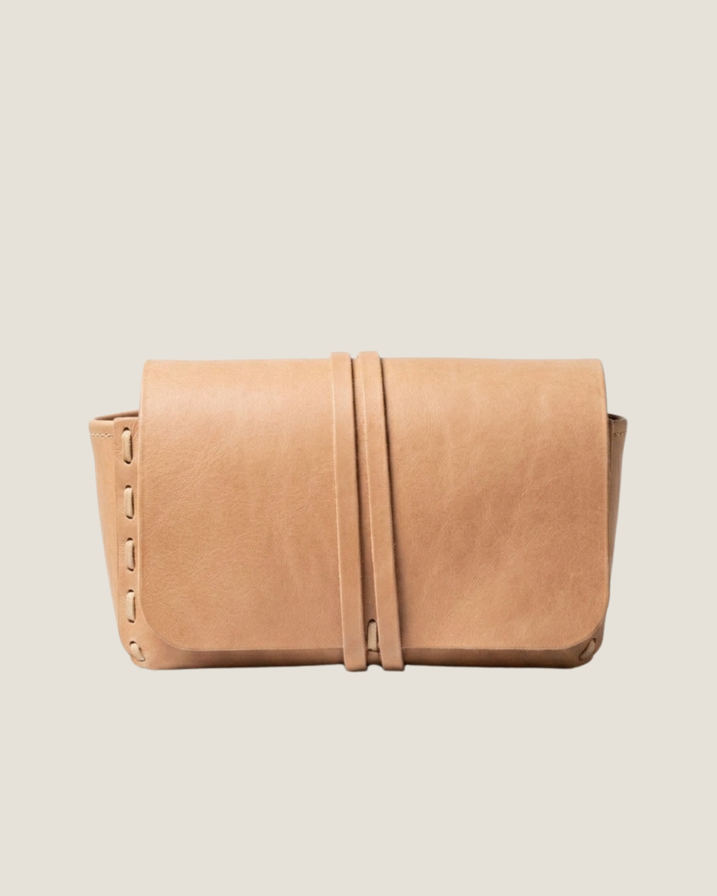 Tan leather clutch bag on a light beige background