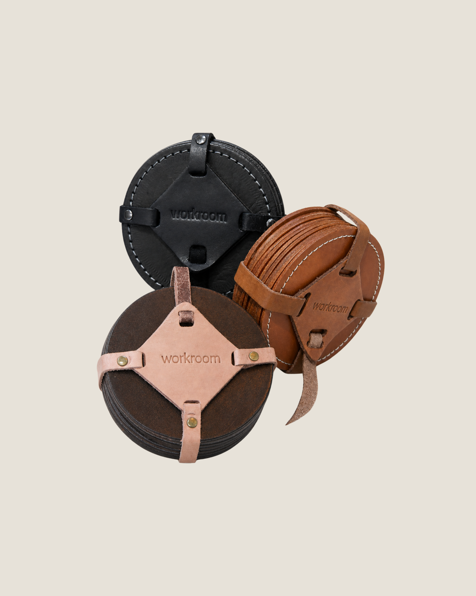 Three leather coasters in black, brown, and beige 