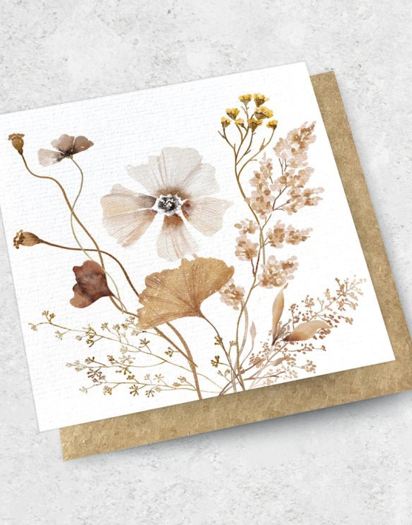The DRIED ARRANGEMENT - GREETING CARD by The Workroom showcases a premium textured design with watercolor depictions of delicate, dried flowers and leaves in earthy tones. It is elegantly presented on a kraft envelope against a light, textured background.