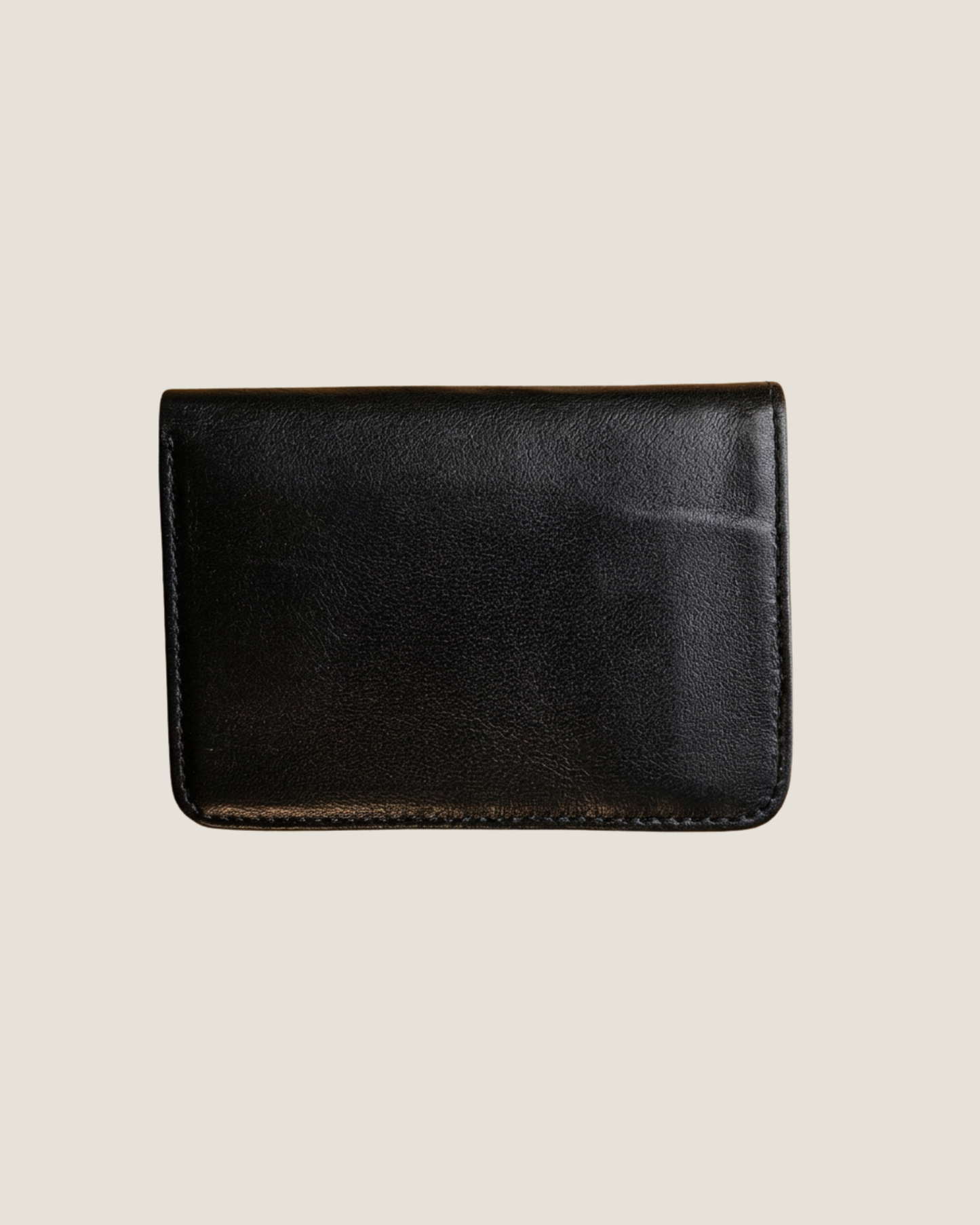 Black leather wallet on a beige background