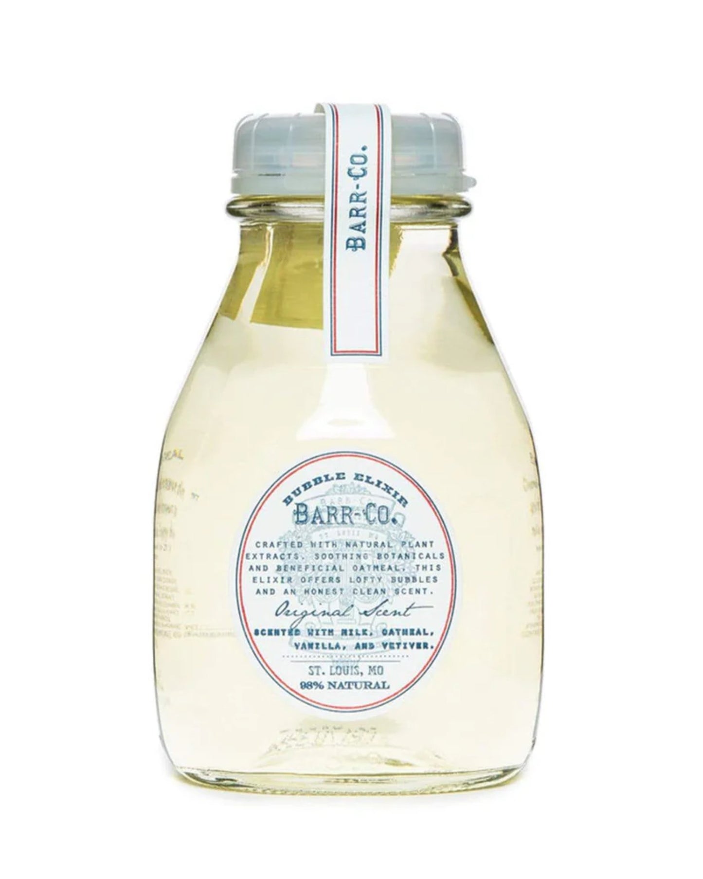 A clear bottle from Barr Co presents an apothecary-inspired design, featuring the label "BARR CO BUBBLE BATH ELIXIR." This luxurious elixir is a bubble indulgence with fragrances of milk, oatmeal, vanilla, and vetiver. The bottle is finished with a small lid and embellished with a decorative tag.