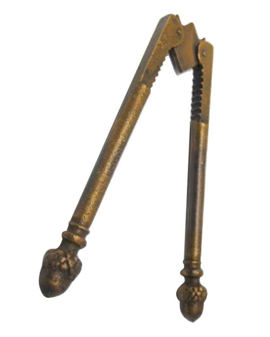 A close-up of the CC Interiors BOMBAY NUT CRACKER showcases its vintage brass design with a rustic metal finish. This classic piece of kitchenware features two hinged arms with decorative ends, making it perfect for cracking open hard shells. The nutcracker appears well-worn and sturdy, exuding timeless charm.