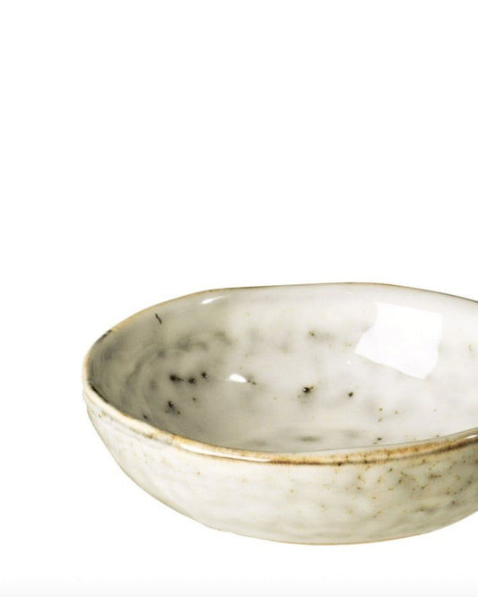 The BUTTER BOWL by Broste, a small off-white ceramic piece with a subtle texture and irregular speckles, embodies Scandinavian elegance. Set against a plain white background, its simple design showcases minimalist modern flair.