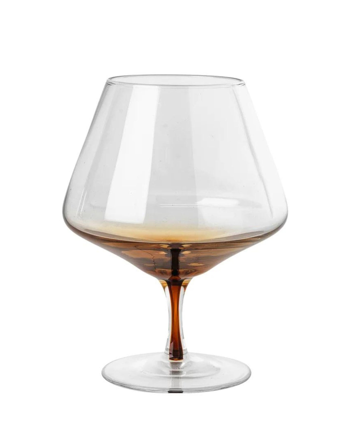 The Broste Cognac Glass from the Smoke collection features a wide bowl and short stem, with an elegant brown gradient at the base. Against a plain white backdrop, its empty form reflects the minimalist beauty of Nordic nature.