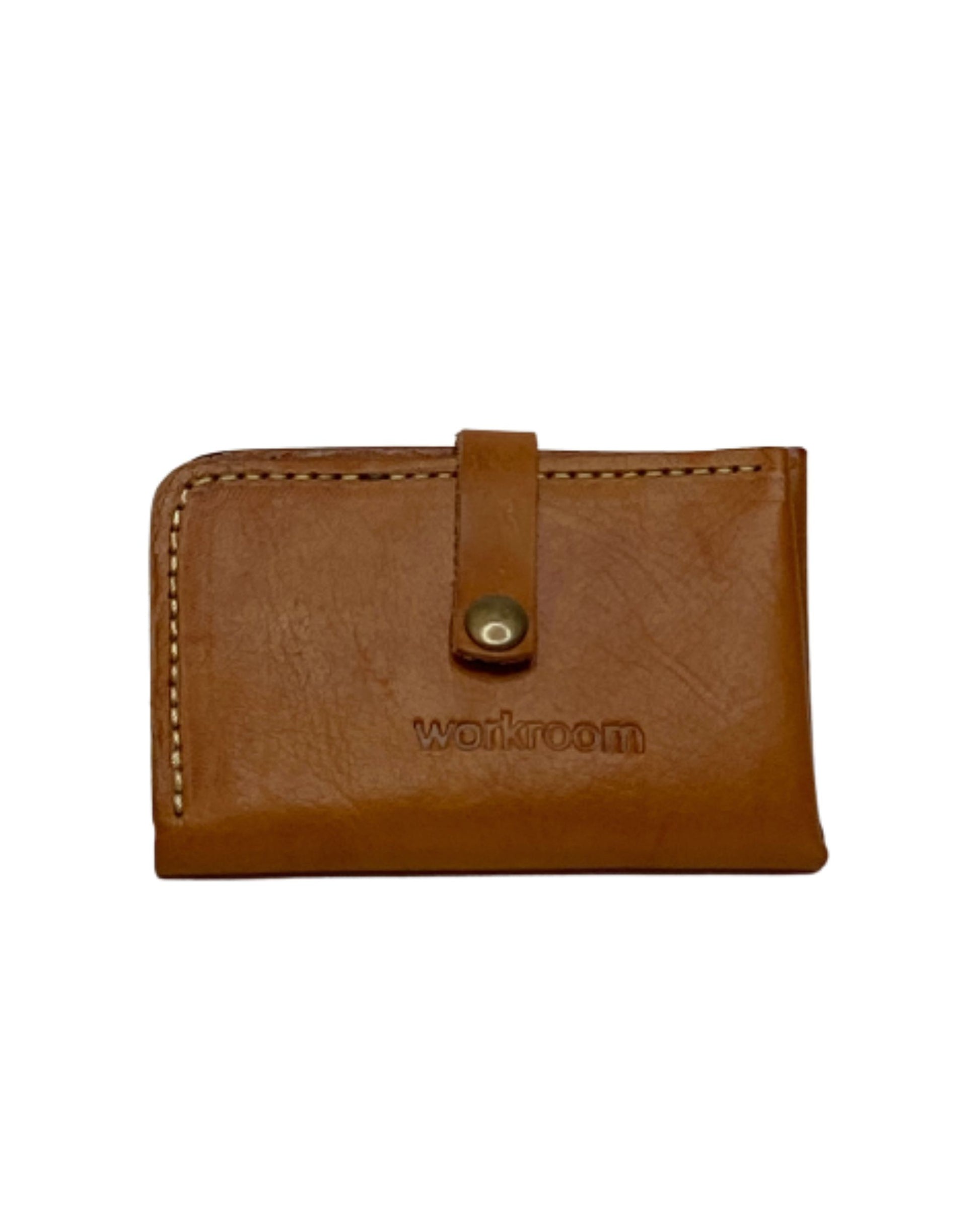 The LEATHER COIN/CARD WALLET by The Workroom is a classic brown leather accessory featuring a button closure and the brand's name expertly embossed on the front. Crafted from full-grain leather, it showcases visible stitching along the edges, combining elegance with durability.