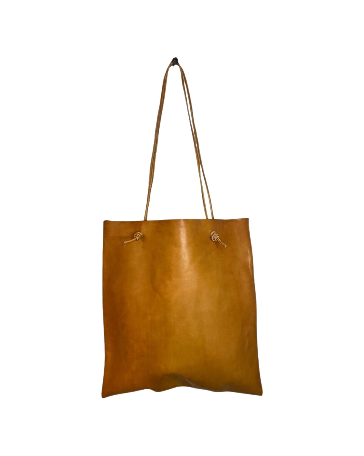 The CUIR KNOT TOTE BAG by The Workroom features a spacious design with two slender shoulder straps, crafted from high-quality brown leather. Its minimalist aesthetic accentuates the smooth texture of the genuine leather, beautifully showcased against a plain white background.