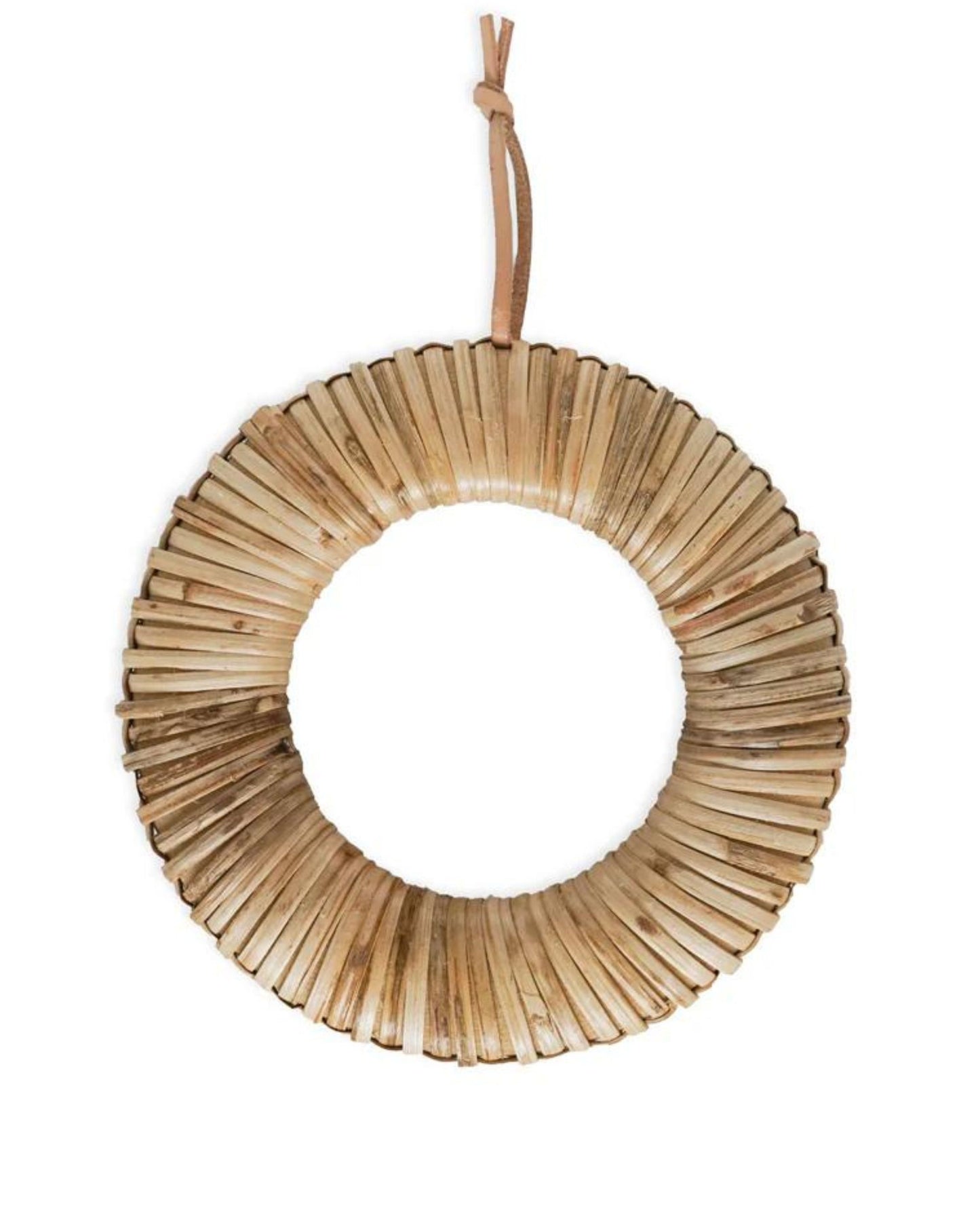 Inspired by the wabi-sabi aesthetic, Society Ink presents a circular wreath that features a natural and textured pattern. Hanging elegantly from a simple leather strap, this piece is crafted from evenly arranged wicker sticks for a rustic and earthy appearance. Its open center highlights the woven design, reminiscent of the Edo Cane Trivet by Society Ink.