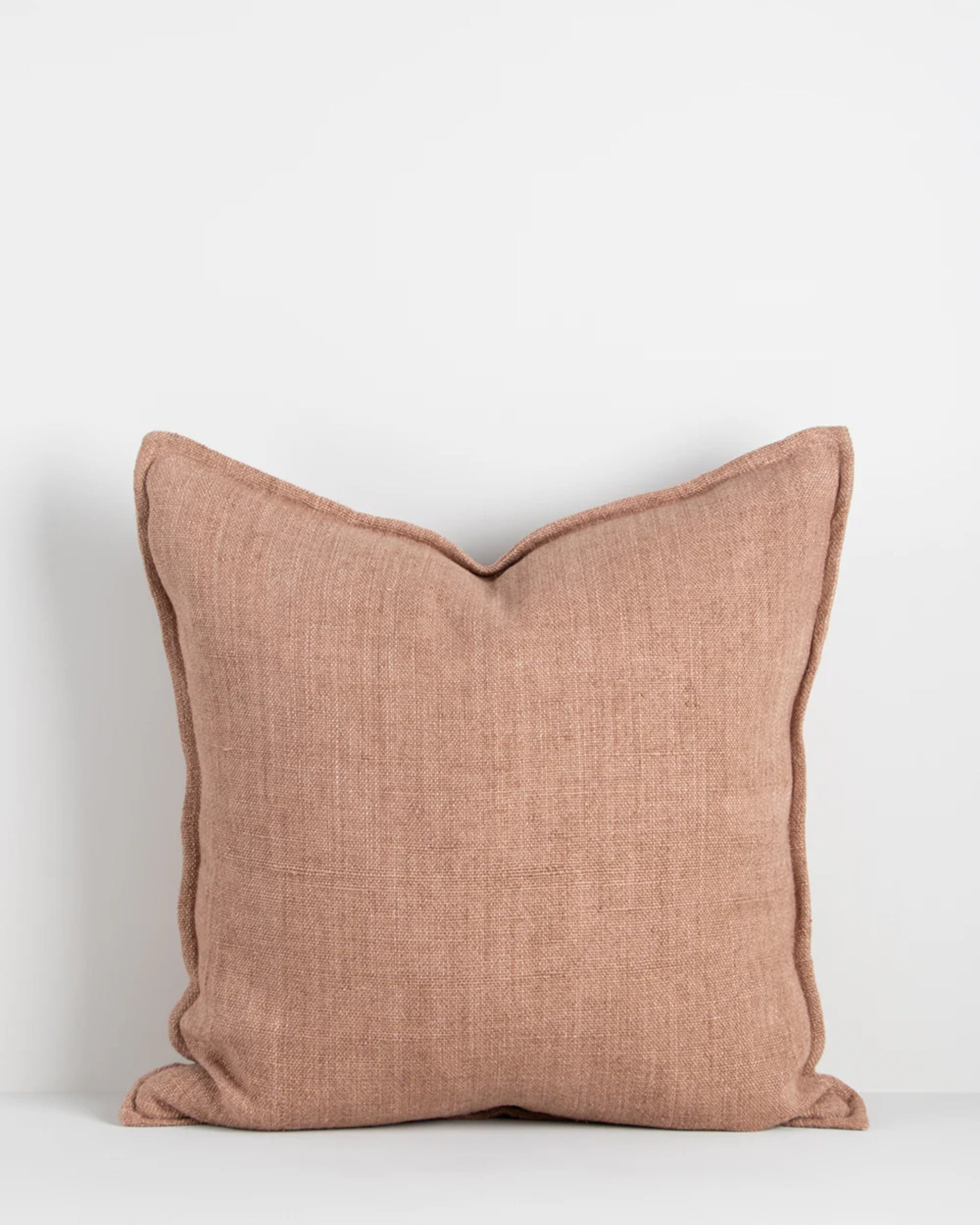 The Baya FLAXMILL HANDWOVEN LINEN CUSHION in cloudburst hue, crafted from raw linen fibers with visible seams, rests against a plain white background. Its minimalistic design and soft texture make it an inviting addition to any space.