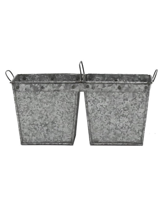 The FLINT DOUBLE PLANTER by Hawthorne is a pair of square-shaped, vintage-inspired planter bins made from reclaimed galvanized iron. Each bin has handles on both sides and features a speckled gray texture, making them ideal for planting lavender.