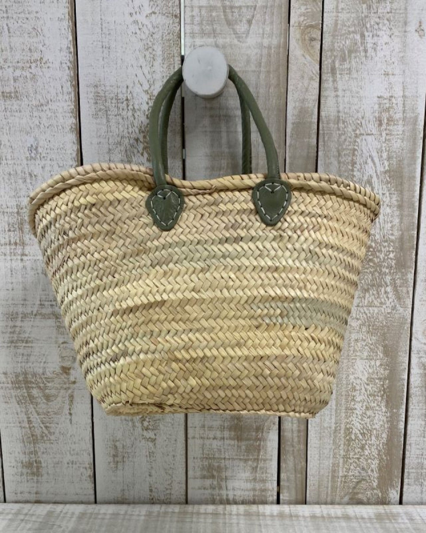 An Epicure Trader FRENCH MARKET BASKET WITH DELUXE HANDLE hangs on a whitewashed wooden wall.