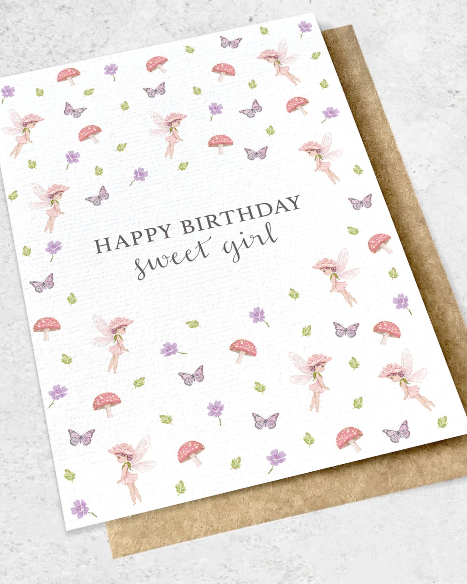 The Ink Bomb's HAPPY BIRTHDAY SWEET GIRL - GREETING CARD showcases a premium textured design with the text, "Happy Birthday sweet girl," surrounded by enchanting illustrations of pink fairies, mushrooms, butterflies, and purple flowers. It includes a matching kraft envelope, making it a delightful keepsake.