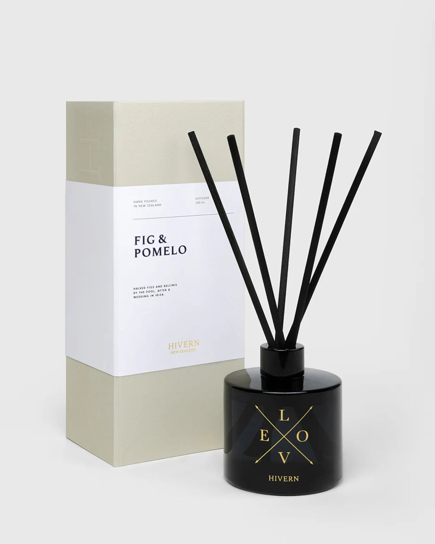 A black bottle of the HIVERN DIFFUSER from Hivern, labeled Love, is elegantly paired with silk fibre reeds for enhanced scent dispersion. The accompanying box reads Fig & Pomelo and features minimalist packaging in beige and white.