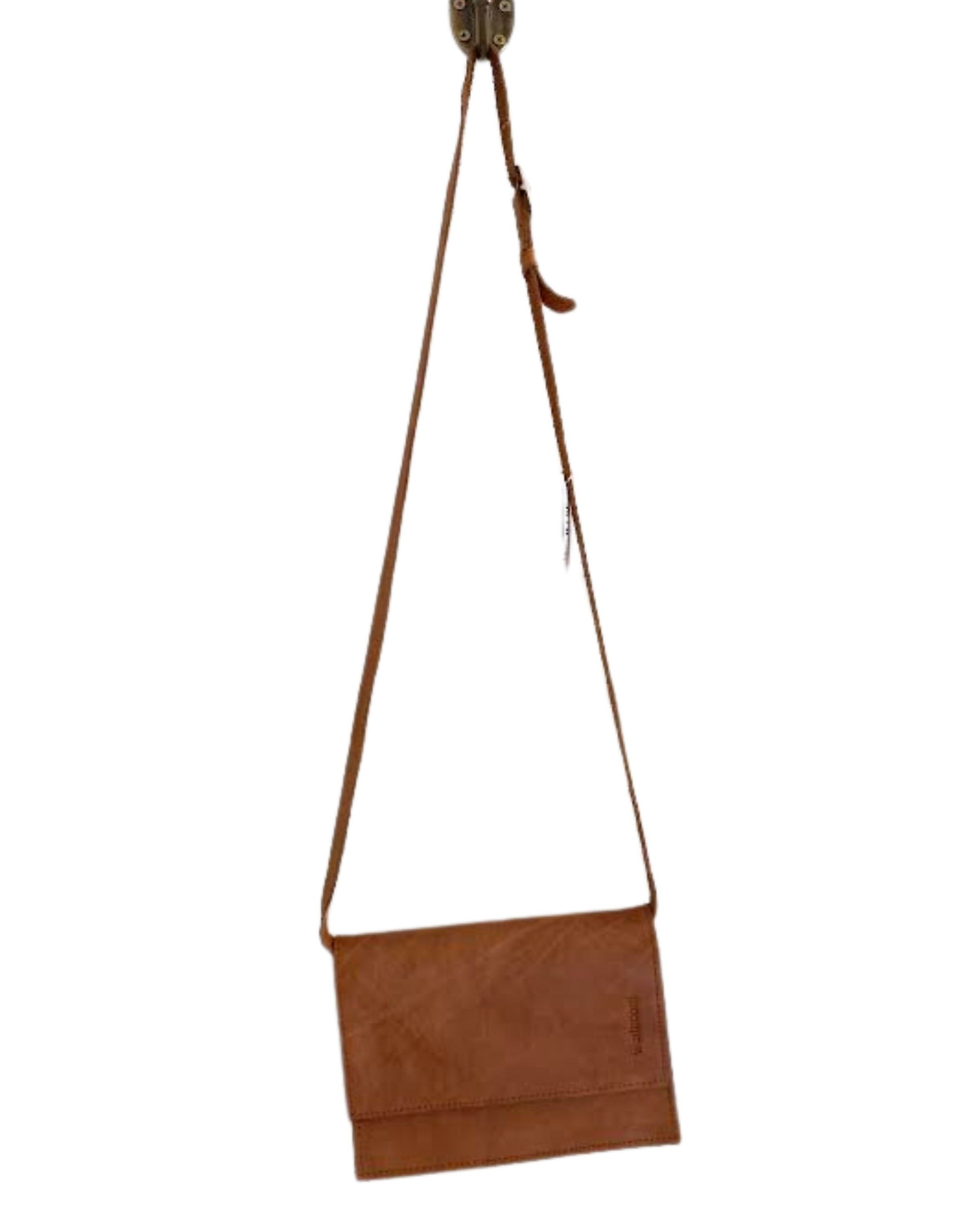 The LEATHER FLAT STRAP PURSE by The Workroom, crafted from brown full-grain leather, hangs on a hook, proudly showcasing its place in the accessory collection. Featuring a simple flap design with a long, flat strap and minimalist stitching, it is perfect for those who appreciate understated elegance.