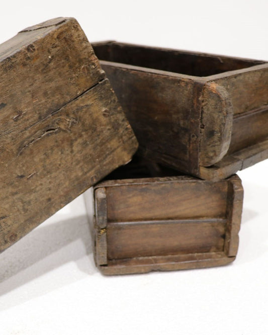 Three Hawthorne BRICK MOULDs, resembling handcrafted items, are stacked on a white surface. These pieces exhibit a rustic look with visible grain and wear, indicating age and use. One mould is positioned on its side, showing the interior.