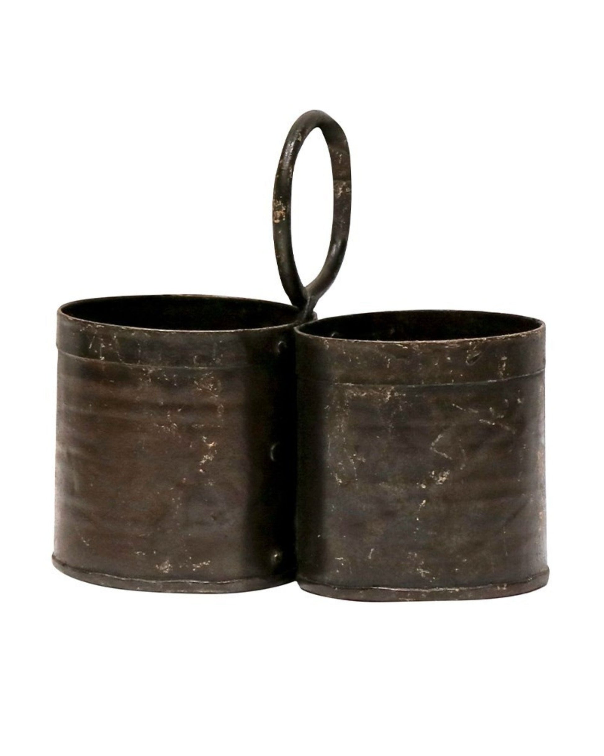 The ORIGINAL METAL HERB HOLDER - DOUBLE by Hawthorne, reminiscent of an original Indian Thali, features a central loop handle. This handcrafted piece showcases a rustic, aged appearance with a patina from years of use and includes two cylindrical compartments attached side by side.