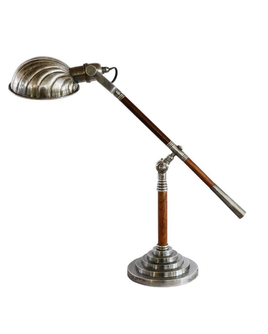 Introducing the SILVER PLATED ADJUSTABLE DESK LAMP by CC Interiors: a vintage-inspired lamp featuring a metallic dome-shaped shade and an adjustable arm. The design incorporates dark-stained wood accents on both the base and arm, with a striking tiered circular base that elegantly combines polished steel and wood elements.