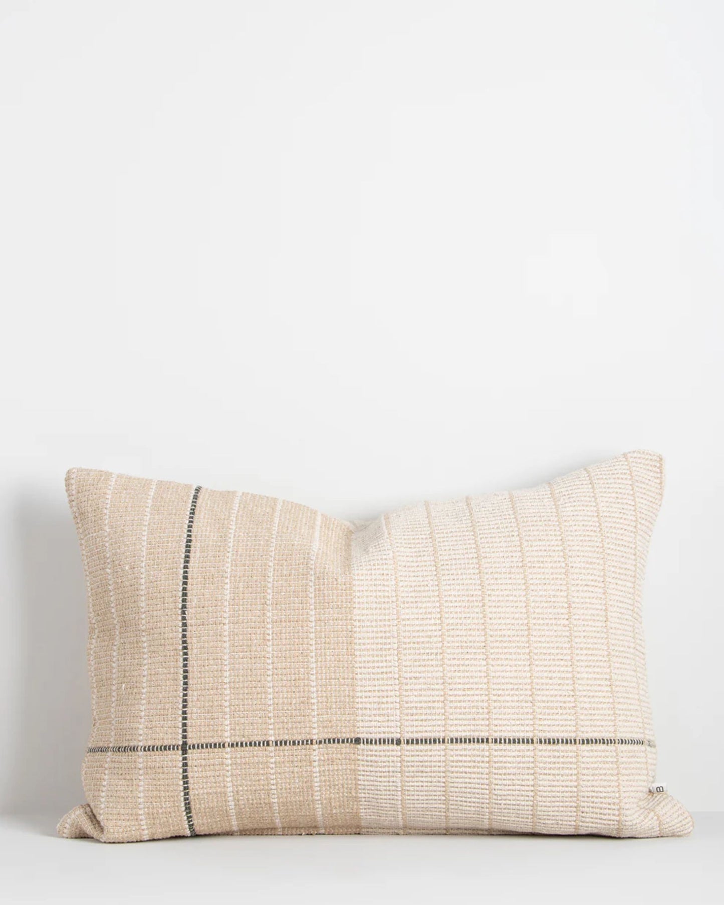 The TAKUMI CAMEL CUSHION by Baya showcases a rectangular shape with thin black and white vertical stripes on a plain white background. Made from a cotton and linen blend, its textured fabric enhances a contemporary aesthetic while providing plush comfort similar to Japanese Tatami mats.