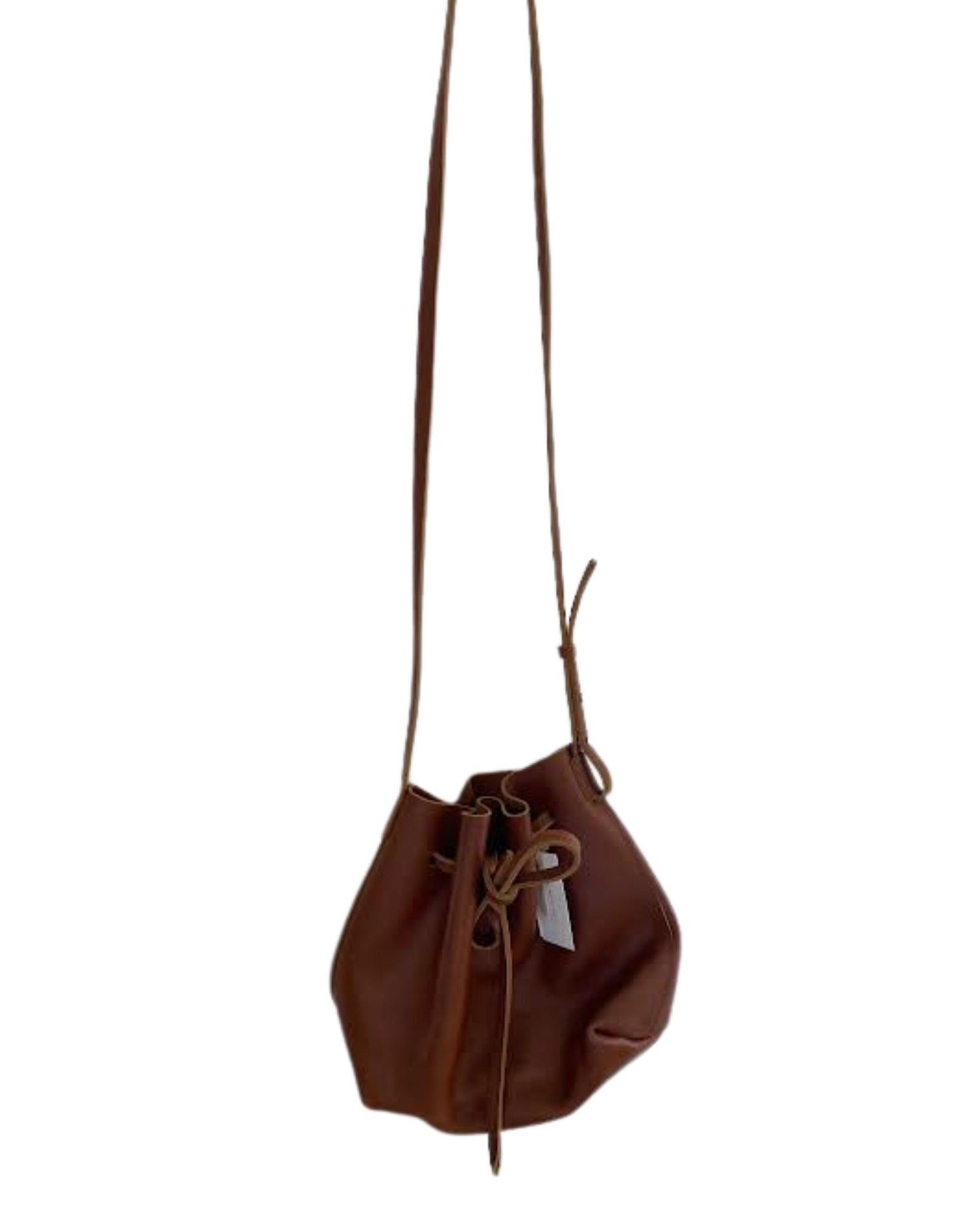 The LEATHER TIE HANDBAG by The Workroom exudes classic charm with its long shoulder strap and drawstring closure, crafted in brown full-grain leather. Its simple and minimalist design makes it a versatile accessory for any occasion.