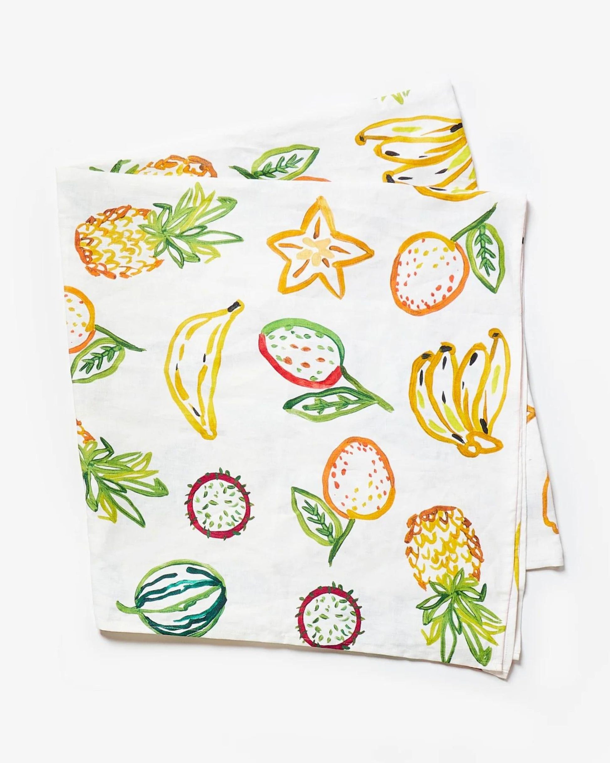 A white linen napkin adorned with original artwork showcasing colorful fruits such as bananas, starfruit, lemons, and melons, accented by green leaves—a perfect complement to your Bonnie and Neil TROPICS MULTI TABLECLOTH.